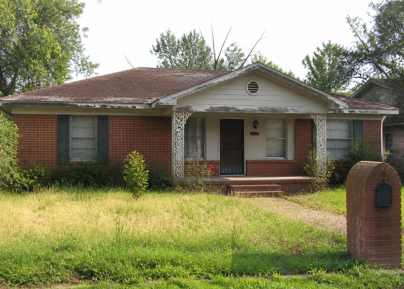 A dated brick ranch that needs repairs before a traditional sale